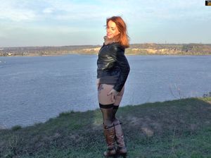 Девушка в чулках и сапогах на улице мастурбирует киску пальчиками