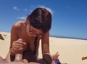 На пляже красивая лапочка в очках делает мастерский отсос