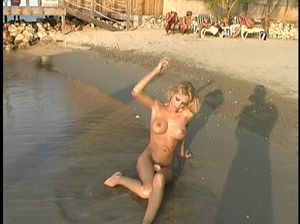 На пляже симпатичная сучка ласкает свою бритую розовую пизду